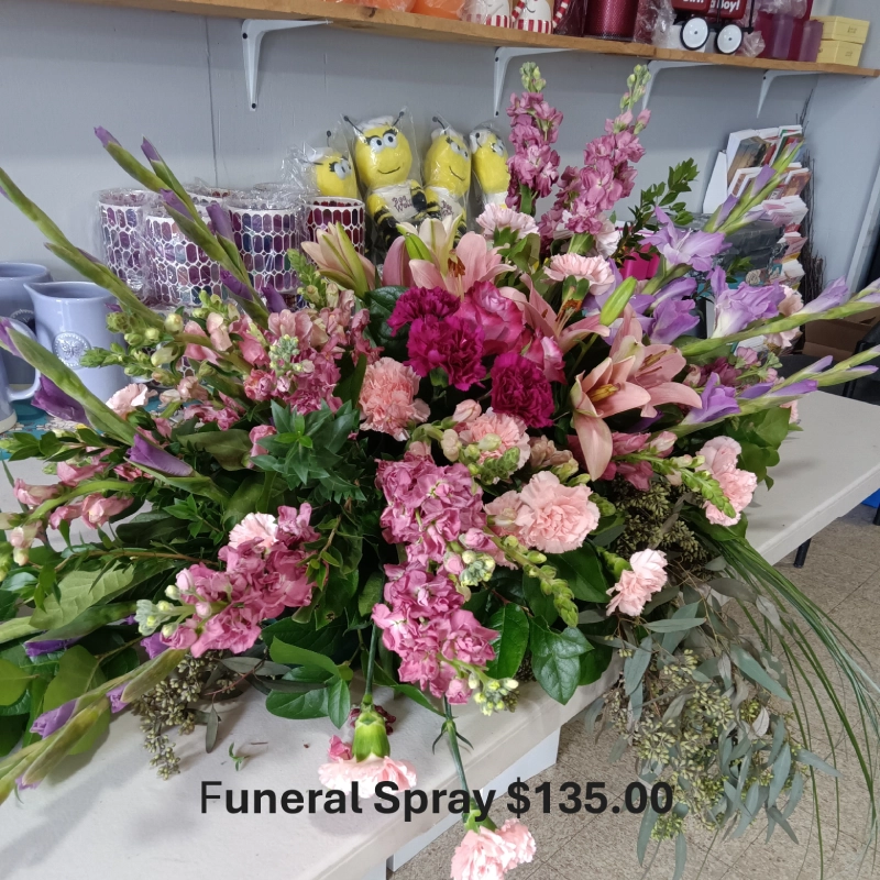Funeral spray with pink and purple flowers.